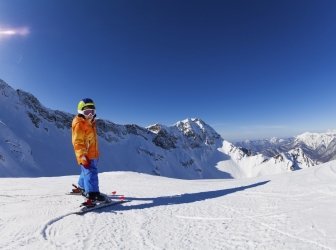 Junge Skifahren bei Sonnenschein mit Blick auf die Berge