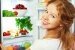 Glückliche Frau und geöffneter Kühlschrank mit Obst und Gemüse