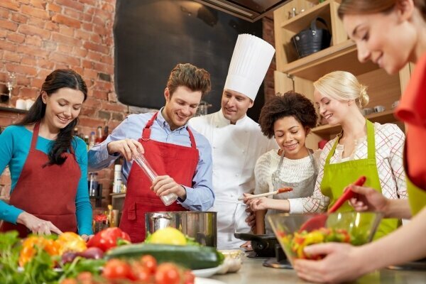 Glückliche Freund und Chefkoch kochen in der Küche