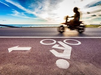 Fahrradstraßenschild mit Mottorrad bei Sonnenuntergang