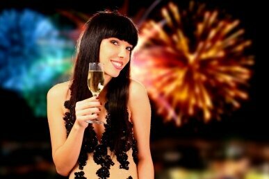 Sexy Frau mit Champagner, Feuerwerk im Hintergrund