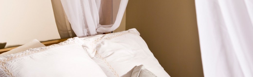 Kissen auf einem weißen Markise-Bett, Quelle: goldenKB / istockphoto