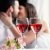 Weingläser mit küssendem Paar im Hintergrund