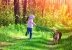Kleines Mädchen mit Hund im Wald