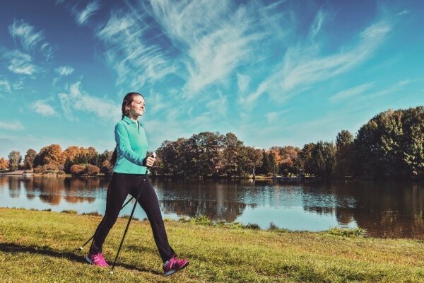 Junge Frau beim Nordic Walking