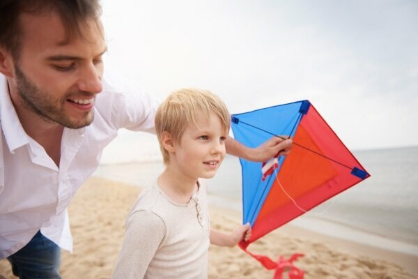 Vater und Sohn spielen mit Drachen