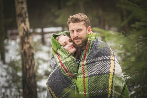 Junges Paar Spaziergang im Winter Wald in warmer Decke