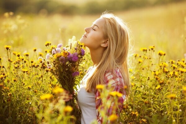 Wunderschönes Mädchen mit Wildblumen im Sommer