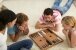 Vier junge Menschen spielen Backgammon