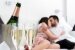 Champagner-Gläser mit küssendem Paar im Hintergrund