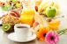 Frühstück mit Kaffee, Orangensaft, Croissants, Salat, Müsli und Ei