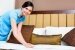 Zimmermädchen macht das Bett in asiatischem Hotelzimmer