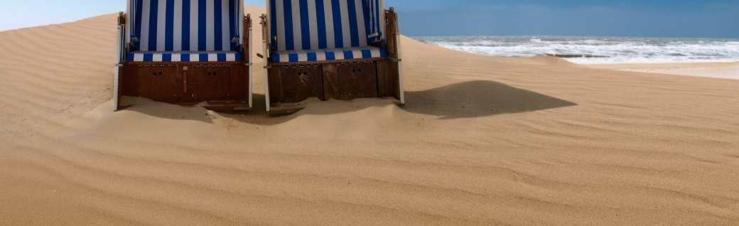Liegestühle auf einer Sanddüne, Quelle:   avarooa / istockphoto