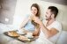 glückliche Mann mit Frau im Luxushotel mit Frühstück im Bett