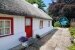 irisches Ferienhaus mit Strohdach und zigeunerhafter Wohnanhänger mit Stroh bedeckt