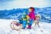Kinder haben Spaß beim Schlittenfahren im Schnee