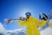 Junger Skifahrer in gelber Jacke, blaue Skibrille und weißer Helm