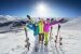 Lächelndes Mädchen in blauer Jacke beim Skifahren in den Alpen