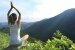 Junge Yoga Frau auf einer Bergspitze