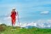 Touristin in rot gekleidet mit verschneiten Bergen im Hintergrund