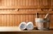 Holzeimer und weiße aufgerollte Handtücher in der Sauna