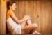 Eine Frau sitzt in der Sauna und relaxt
