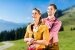 Paar in Tracht auf einem Berggipfel der Alpen im Urlaub
