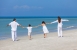 Mutter, Vater und Kinder laufen am Strand