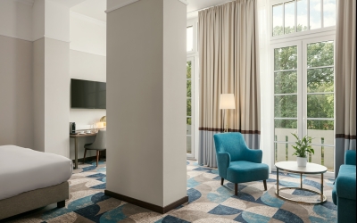 Das großzügige Platzangebot eines der größten Zimmer in modernem Design mit hohen Decken und einem atemberaubenden Blick auf den angrenzenden Park, zusammen mit dem exzellenten Service des Hotels, garantiert Ihnen einen unvergesslichen Aufenthalt.