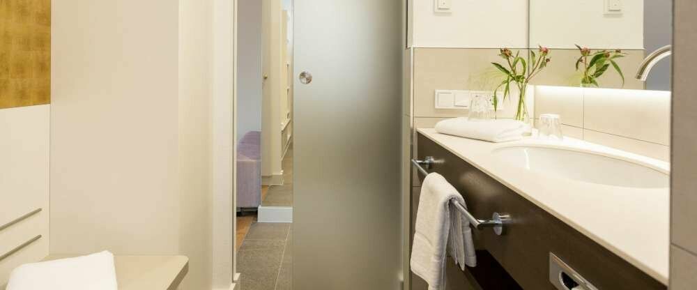 Die modernen Bäder verfügen über eine große Dusche, Fußbodenheizung, Ablagefläche und Sitzmöglichkeit sowie Kosmetikspiegel und Föhn.