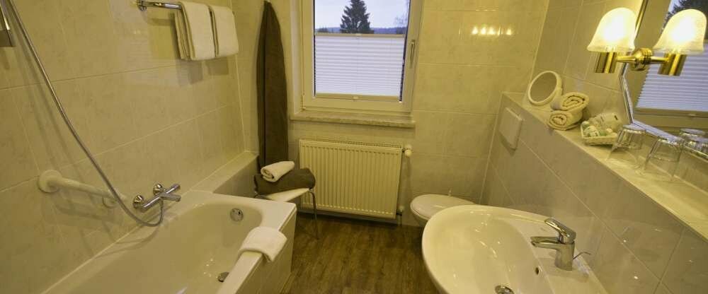 Die Badezimmer im waldhotel AUSZEIT sind mit Wanne/Sitzdusche oder Dusche ausgestattet. Beispiel hier: Badezimmer mit Wanne/Sitzdusche