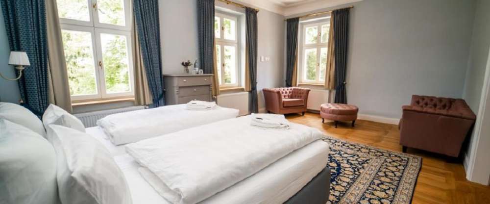 Lichtdurchflutet und weitläufig eröffnet die Blaue Suite den Blick auf den alten Baumbestand des Schlosshotels. Ein separater Ankleidebereich und eine Badewanne zeugen von großzügigen Platzverhältnissen. 