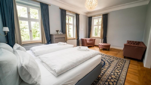 Lichtdurchflutet und weitläufig eröffnet die Blaue Suite den Blick auf den alten Baumbestand des Schlosshotels. Ein separater Ankleidebereich und eine Badewanne zeugen von großzügigen Platzverhältnissen. 