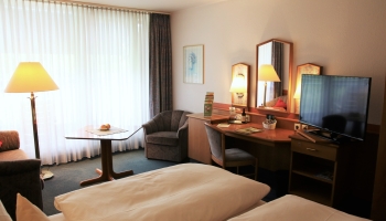 praktisches Classic Doppelzimmer zur Einzelnutzung mit 2 Einzelbetten bzw. Doppelbett (0,90 x 2,00 m pro Bett), Teppichboden, gemütlicher Sitzecke, Minibar, Fernseher, Bad mit Dusche, Balkon mit Sitzmöbel