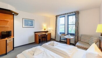 Das Deluxe Doppelzimmer verfügt über ein komfortables Doppelbett, Kleiderschrank, einen Schreibtisch, Safe, Fenster mit Ausblick auf die Gartenanlage sowie ein eigenes Bad mit Badewanne oder Dusche.