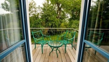 Das Deluxe Doppelzimmer mit Balkon verfügt über ein komfortables Doppelbett, Kleiderschrank, einen Schreibtisch, Safe, einen Balkon mit Balkonmöbeln und Gartenblick sowie ein eigenes Bad mit Badewanne oder Dusche.