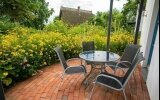 Das Deluxe Doppelzimmer mit Terrasse verfügt über ein komfortables Doppelbett, Kleiderschrank, einen Schreibtisch, Safe, eine Terrasse mit Terrassenmöbeln und Gartenblick sowie ein eigenes Bad mit Dusche.