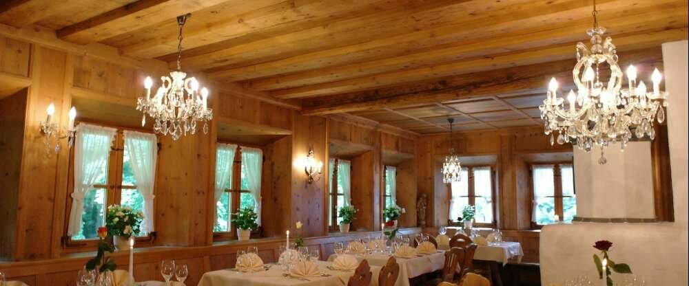 Unsere Ofenstube befindet sich etwas erhöht mit Aussicht in den Wald Richtung Isar. Diese Stube bietet Platz für bis zu 40 Personen und ist urgemtürlich mit viel Holz und schönen Echtkristalllüstern. Dazu der Kachelofen für wohlige Wärme im Winter