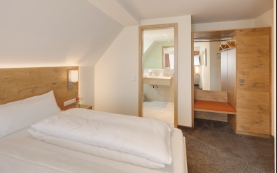 Auf ca. 22m² wohnen Sie in Doppelzimmer, welche gerne auch zur Einzelnutzung gebucht werden können. Hier finden Sie erholsamen Schlaf in einem Queen- (200x160cm) oder einem Kingsize Bett (200x180cm) mit Tiefschlafmatratze.