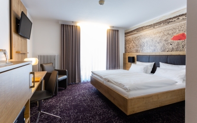 Moderne, helles Hotelzimmer mit Doppelbetten, teilweise Balkon und mit allem, was heutzutage zu einem pfiffigen Hotelzimmer dazu gehört. Wohnliche Materialien und aktuelle Farbkombinationen mit flottem Design. Einfach zum Wohlfühlen. Badezimmer mit Fenste