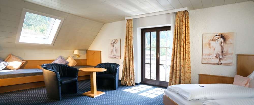 Großzügig geschnittenes Doppelzimmer im Dachgeschoss, nur mit Treppe erreichbar und Blick auf den Wald, Teppichboden, Sofabetten, Dusche/ WC, TV, Fön, Kosmetikspiegel, Schreibtisch, Safe und Balkon .