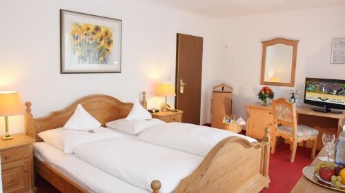 Das Doppelzimmer Heimatgefühl im Antoniushof bietet gemütlichen Wohnkomfort auf 20 m². Ausgestattet mit einem komfortablen Boxspringbett (Bettengröße 1,40 x 2,10 Meter) mit 5 cm Topping, Dusche und einem Sessel zum Entspannen, ist es der ideale Rückzugsor