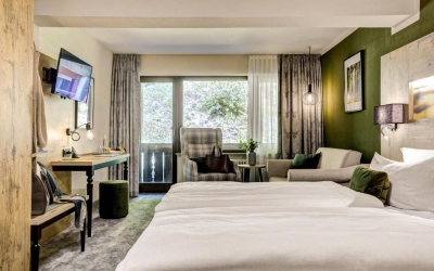 24 – 30 m². Gehobene Ausstattung mit einem Doppelbett mit zwei Matratzen á 90×200 cm, Hangseite/Schattenseite, Balkon, zwei Betten / Doppelbett, neu/zeitgemäß/gemütlich eingerichtet, Teppich-Fußboden, Sitzplatz, Schreibtisch Safe, Flach TV, W-Lan, neues B