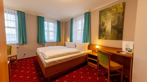 Unsere Komfortzimmer verbinden eine gemütliche, klassische Einrichtung mit funktionalem Komfort und einer ruhigen Atmosphäre. Auf ca. 19m² bis 32m² erwartet Sie ein liebevoll gestalteter Raum für bis zu zwei Personen, ideal für erholsame Nächte und entspa