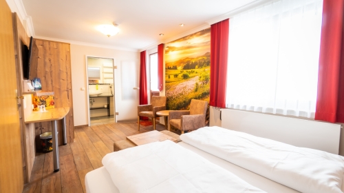 Unser Doppelzimmer Landromantik mit Balkon verbindet romantischen Landhausstil mit modernem Komfort. Warme Farben und liebevolle Details schaffen eine einladende Wohlfühlatmosphäre. Der Balkon bietet einen schönen Blick ins Grüne oder auf das Dorf.

Ein