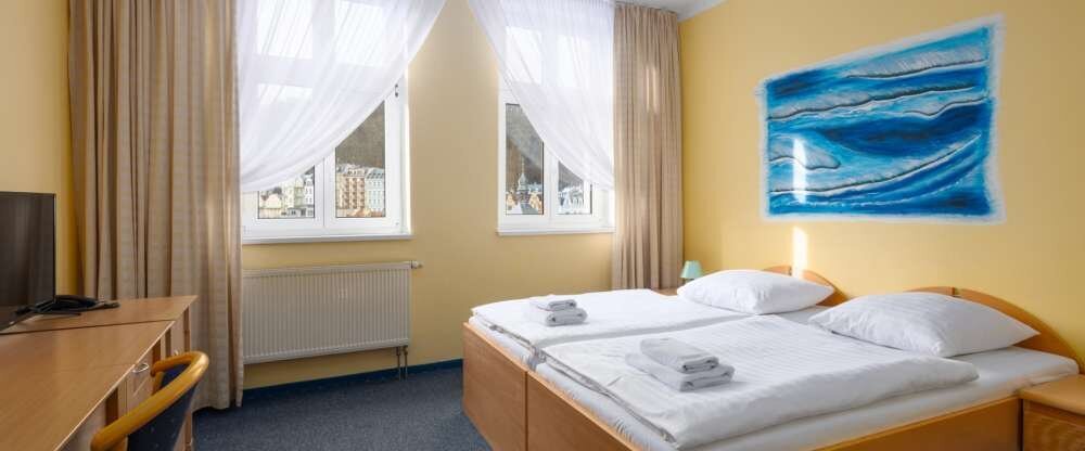 Das Standard-Doppelzimmer mit Blick auf die Karlsbader Altstadt ist der ideale Ort für einen komfortablen Aufenthalt im Herzen der Kurstadt. Das Zimmer ist im klassischen Stil eingerichtet und verfügt über ein Doppelbett oder zwei Einzelbetten. Zu den Ann