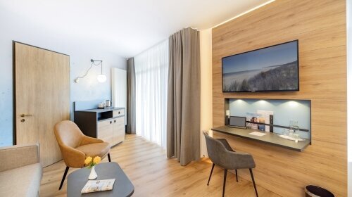 Hier lässt man es sich gut gehen! Äußerst geräumige Zimmer in der 3. Etage mit einer Kaffee-Tee-Station und einem zusätzlichen Sitzbereich mit Sofa und Tisch. Die großflächigen Fensterfronten mit dem französischen Balkon lassen viel Sonne und Licht herein