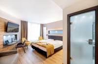 Hier lässt man es sich gut gehen! Äußerst geräumige Zimmer in der 3. Etage mit einer Kaffee-Tee-Station und einem zusätzlichen Sitzbereich mit Sofa und Tisch. Die großflächigen Fensterfronten mit dem französischen Balkon lassen viel Sonne und Licht herein