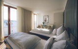 Helles, elegantes Gästezimmer (28 qm) mit großen Fenstern, ausgestattet mit Doppelbett (2,00 x 2,10 m) oder zwei Einzelbetten (je 0,90 x 2,10 m).