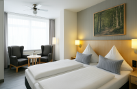 Entspannen Sie in Ihrem 20m² gemütlichen Schlafbereich mit Boxspring-Doppelbett und antiallergischen Bettwaren (1,80 m breit), Schreibtisch mit Hocker, kleiner Sitzecke mit 2 Sesseln und Tisch, Flat-TV, Badezimmer mit Dusche / WC auf 2,5 m², sowie Vinylbo